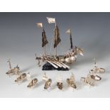 A Chinese silver coloured model of a junk ship, modelled with three masts in full sail, eight ores