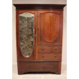 An Edwardian mahogany compactum wardrobe, formed with a shield shaped panelled cupboard door, over