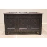 A late 17th century/early 18th century carved oak coffer, the three panel cover opening to a