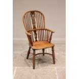 A 19th century yew and ash hoop back Windsor elbow chair, with a pierced splat over a shaped seat
