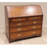 A George III oak and mahogany cross banded bureau, the fall front opening to a compartmentalised