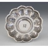 A Chinese silver coloured saucer, of lobed circular form with shaped border, raised on tapered foot,