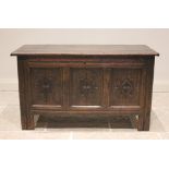 An early 18th century oak coffer, the three plank top opening to a fitted candle box, above the