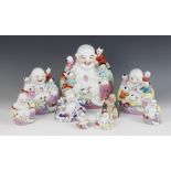 A selection of nine Chinese porcelain models of laughing Buddha and children, predominantly