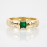 An emerald and diamond ring, the central rectangular step cut emerald measuring 3.8mm x 4.8mm, to an