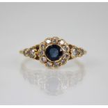 An early 20th century sapphire and diamond floral cluster ring, the central round mixed cut sapphire