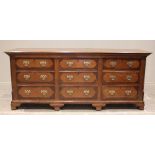 A George III oak and mahogany crossbanded dresser base, the rectangular moulded plank top above an