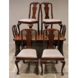 An Edwardian walnut extending dining table, the rectangular top with canted corners, raised upon