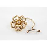 An Edwardian diamond and pearl floral pendant brooch, the central old cut diamond set to a yellow