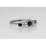 A sapphire and diamond five-stone ring, the central round mixed cut sapphire measuring 4mm diameter,