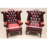 A pair of George III style ox-blood red leather wing back armchairs, late 20th century, each with an