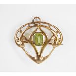 An Art Nouveau peridot set brooch/pendant, the central rectangular step cut peridot measuring 7.