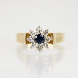 A sapphire and diamond 18ct gold cluster ring the central round mixed cut (untested) sapphire