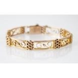 A 9ct gold bracelet, each rectangular panel with pierced scroll detail, interspersed by