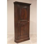 A George III oak freestanding corner cupboard, the single full length door with two fielded panels