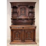 A late 19th/early 20th century French walnut dresser, the raised back with a central carved cupboard