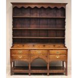 A George III oak high back pot board dresser, the moulded cornice above a scalloped frieze and three