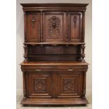 A late 19th/early 20th century French walnut side cabinet, the upper section with three carved doors