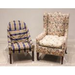 An Edwardian wing back armchair, later re-covered in foliate fabric, the arched padded back