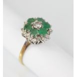 An emerald and diamond floral cluster ring, the central round brilliant cut diamond with a 0.35