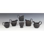 A Wedgwood black basalt milk jug, early 20th century, of ovoid form with angled scroll handle,