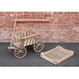 A rustic pine dog cart, of typical tapering slatted form, upon an articulated front axle and iron