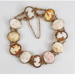 a carved shell cameo gold coloured bracelet, comprising eleven oval carved shell cameos depicting