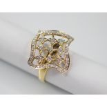 A diamond set swivel head ring, the shaped square head with pierced detail set with round mixed