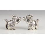 A pair of continental silver squirrel figures, each modelled resting on hind legs eating a nut