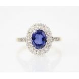 A synthetic sapphire and diamond 18ct gold ring, the central oval mixed cut tanzanite measuring