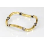 A continental gold coloured bracelet, comprising six wave shaped plain polished yellow gold coloured