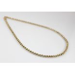 An gold coloured chain, the faceted belcher link chain with spring ring and loop fastening, spring