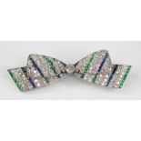 An Art Deco diamond, sapphire and emerald bow brooch, the central round old cut diamond weighing