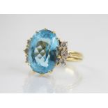 A blue topaz and diamond cocktail ring, the oval mixed cut topaz measuring 16mm x 12mm x 8.5mm, with