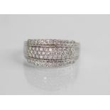 A diamond set 18ct white gold ring, the raised central channel pave set with three rows of round