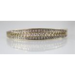 A 9ct gold diamond set hinged bangle, the central channel designed as a pierced greek key border
