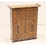 A Korean elm medicine cabinet, 20th century, with a pagoda top above an arrangement of small drawers