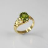 A peridot and diamond 18ct gold ring, the central oval mixed cut peridot measuring 10mm x 8mm,