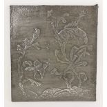 An Arts and Crafts hammered pewter plaque, cast in relief with fish amongst seaweed, impressed