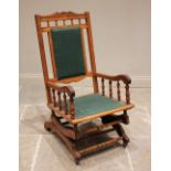 A late 19th century walnut American rocking chair, with an open spindle gallery above a padded