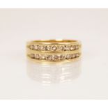 A diamond 18ct gold ring, comprising two rows of graduated round brilliant cut diamonds, channel set