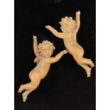 Two carved lime wood cherubs, 19th century, each modelled with arms raised, both lacking wings,