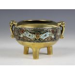A Chinese bronze champlevé enamel tripod censer, the polished bronzed body of compressed form