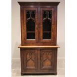 A Victorian oak Gothic library bookcase, the moulded cornice above a pair of glazed doors applied