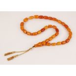 An amber beaded necklace, designed as a row of cylindrical beads, measuring between 14.5mm x 10mm