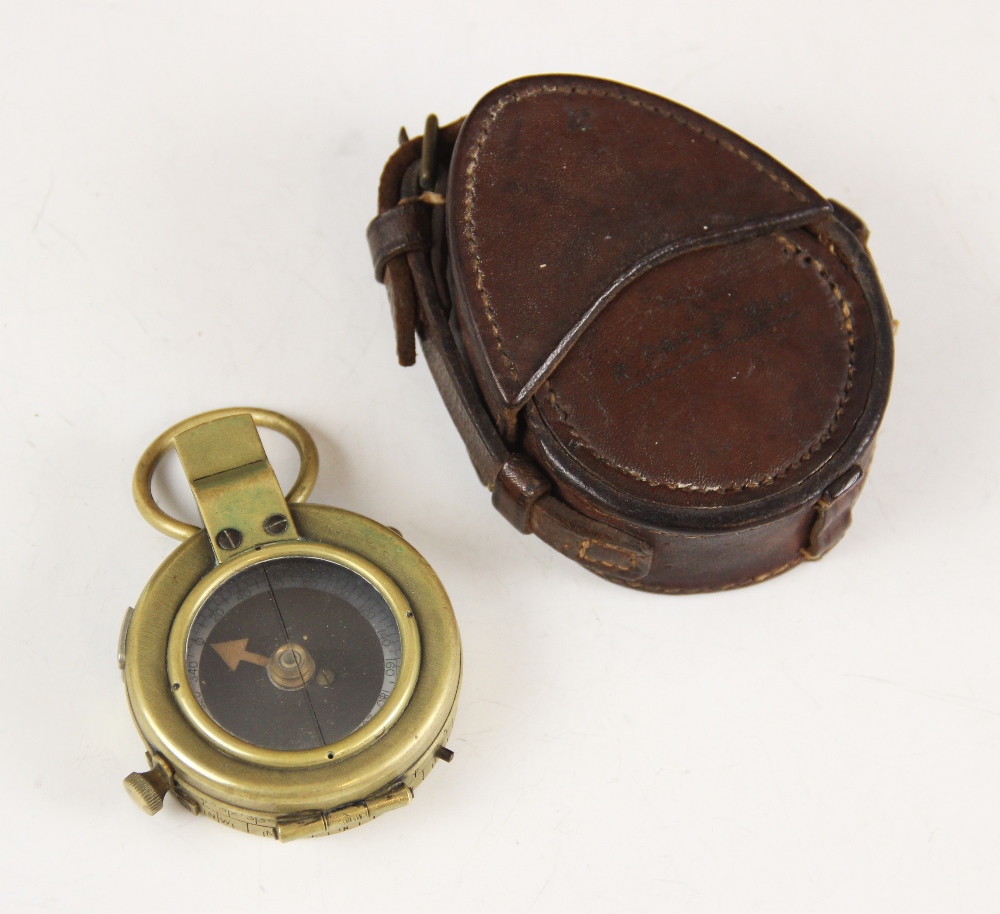 A cased WWI military brass bodied pocket compass, the base with broad arrow, serial number F-L No.