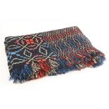 A traditional Welsh blanket, the double-sided geometric design in black, purple, blue and red,
