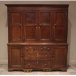 A George III oak housekeepers cupboard, the moulded cornice above an arrangement of four panelled