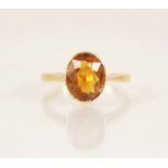 An early 20th century 18ct gold yellow gemstone set dress ring, the central oval mixed cut yellow