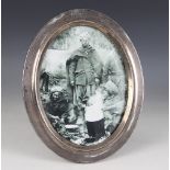 A George V silver mounted photograph frame, Birmingham 1918 (maker's mark worn), of oval form, plain